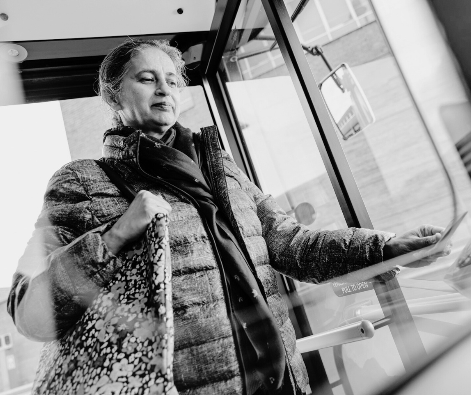 A woman scanning her ticket as she boards the bus.