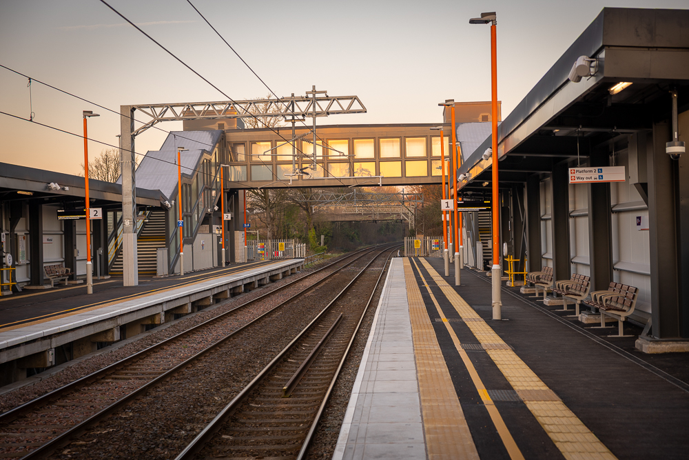 An image of the platform and train tracks and Willenhall railway station, taken at sunrise.